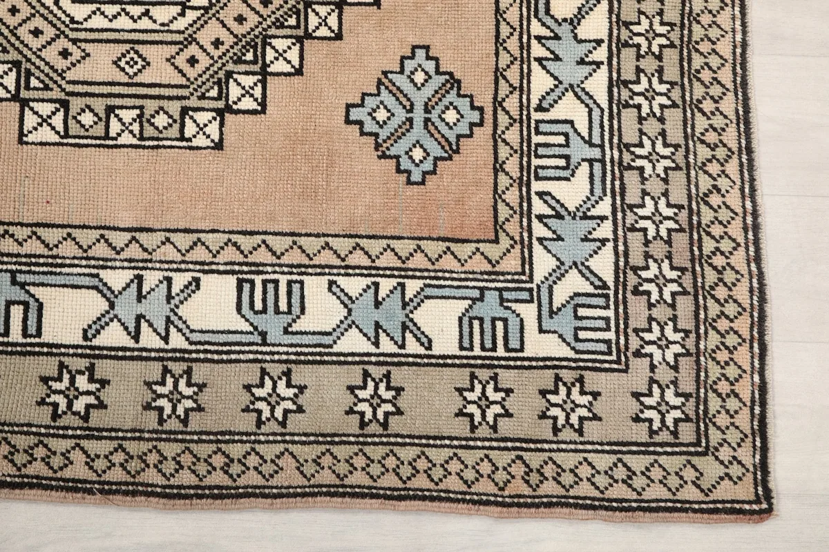 Detailed view of the corner of the rug, showing the geometric border and field pattern.