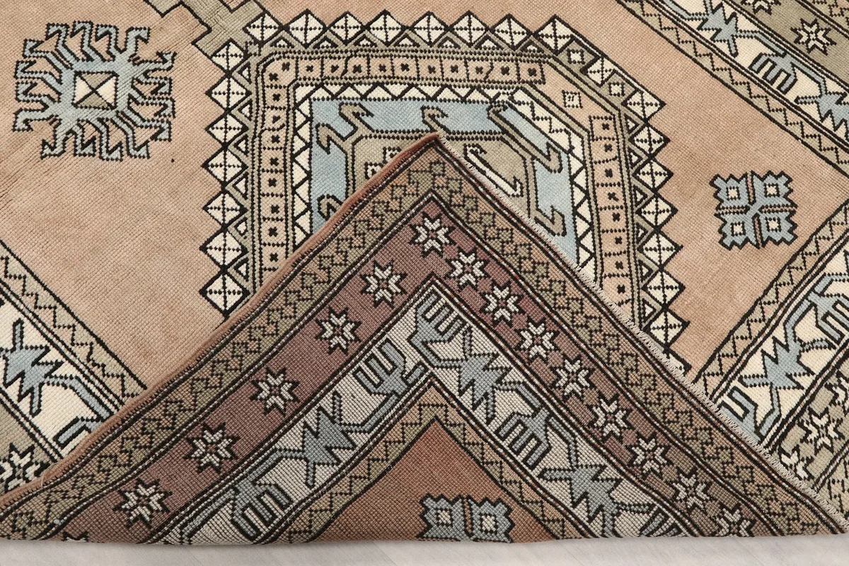 Corner of the rug folded to reveal the reverse side and the density of the hand-knotted structure.