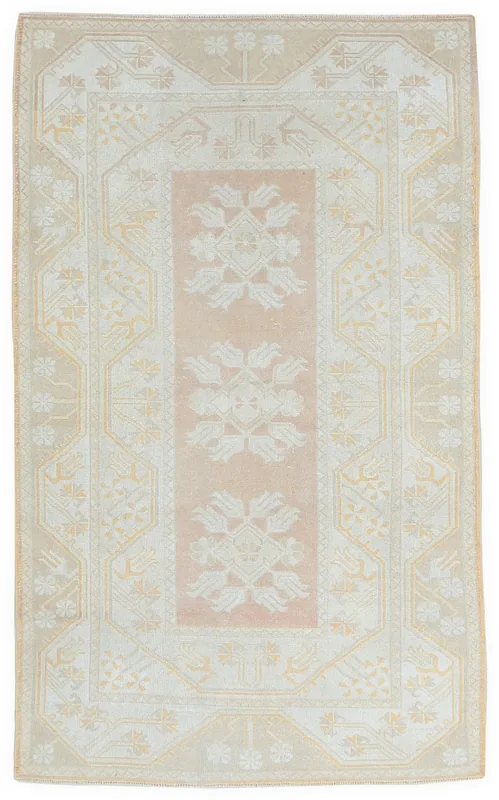 Full overhead view of the beige and rose vintage Anatolian rug on a white background