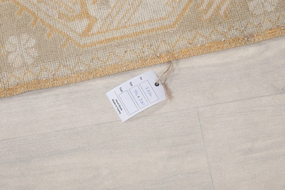 Close-up of the rug's edge with a product tag displaying size and material information