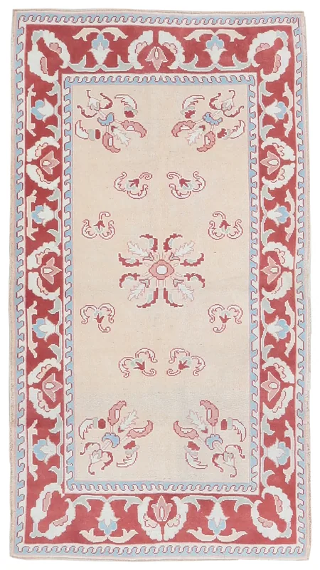 Full top view of the 4'1" x 6'3" beige vintage Anatolian rug with red floral border on a white background.