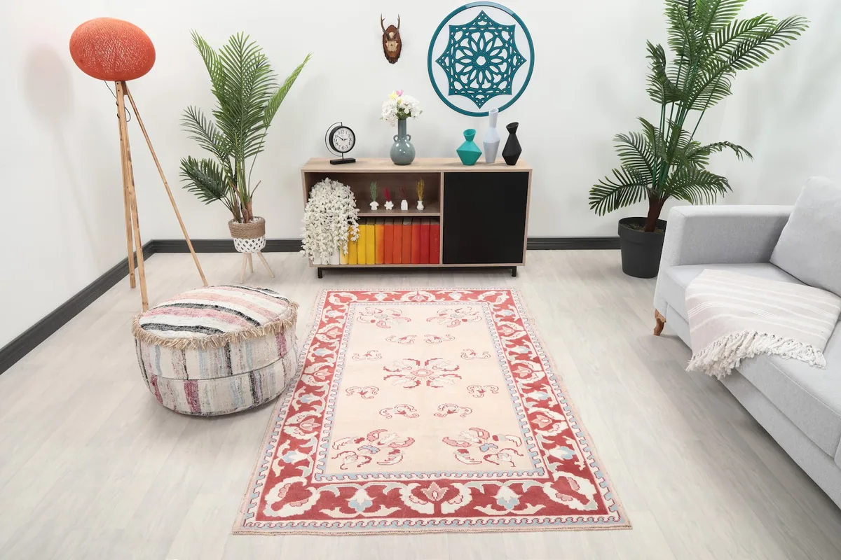 Vintage Anatolian rug displayed in a bright living room setting with a light gray sofa and wooden cabinet.