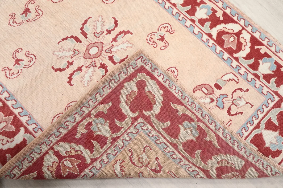 Folded corner of the rug, revealing the thickness of the wool pile and details of the design.