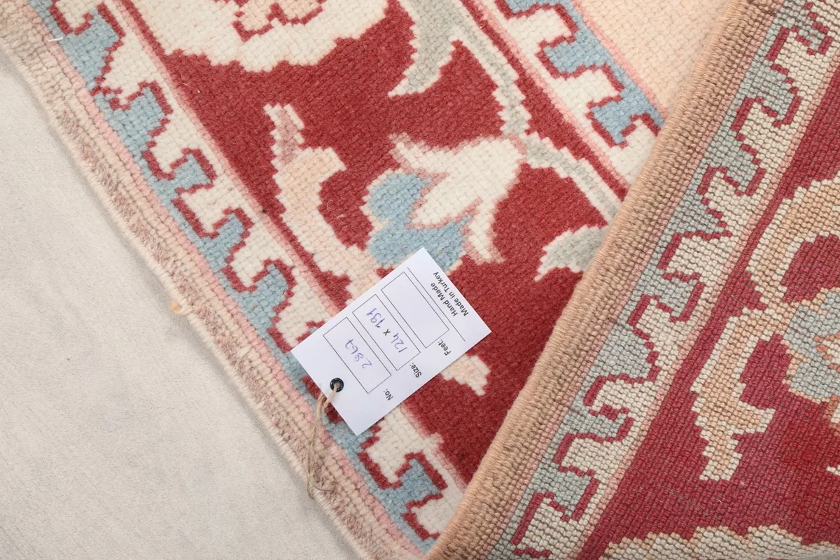 Close-up of the rug's label with size information, next to the fringe and border.