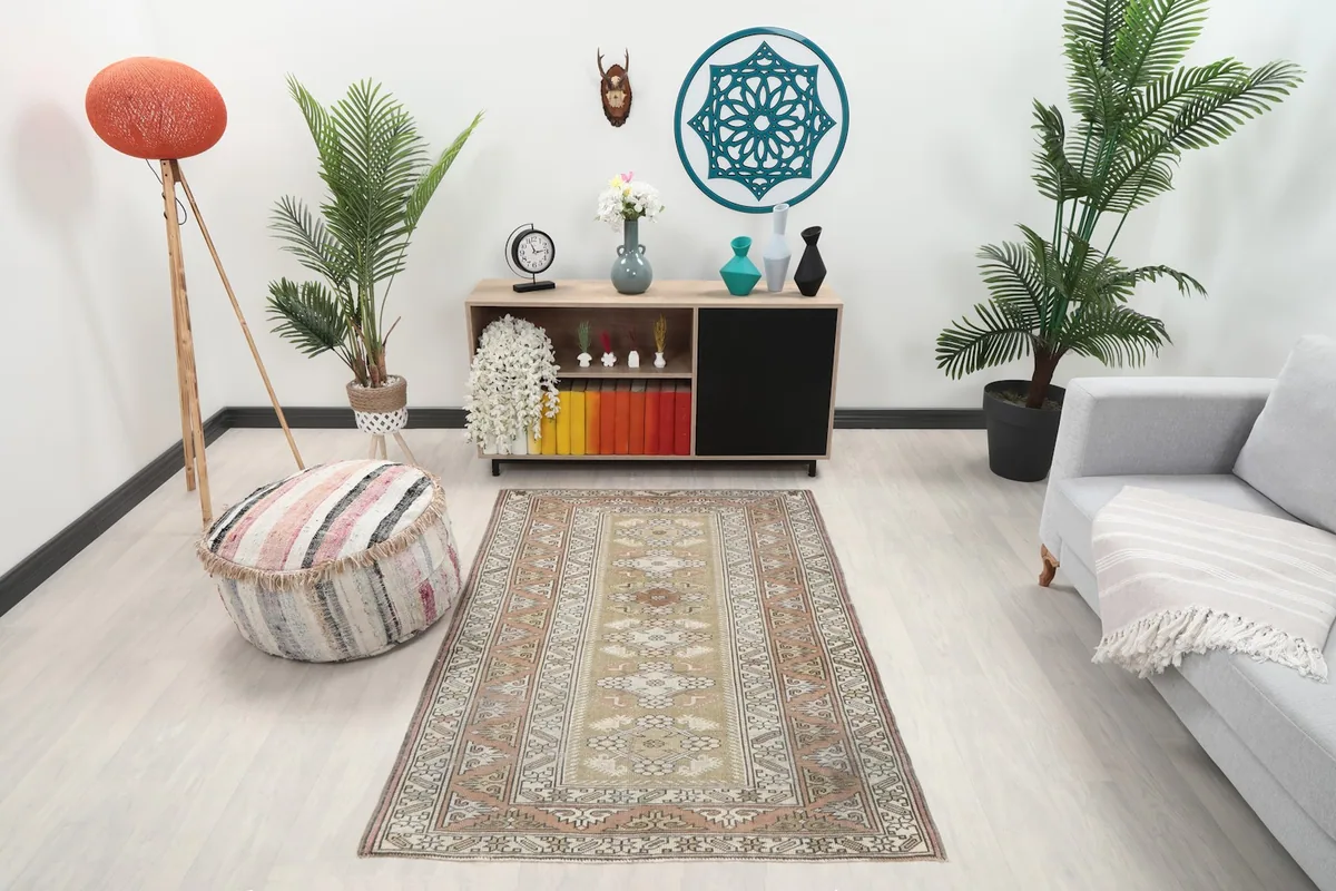 Beige and rust vintage rug in a modern living room setting with a light sofa and plants