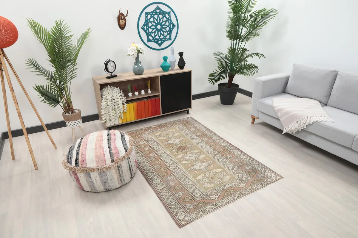 Angled view of the beige and rust vintage rug in a living room, showing its placement