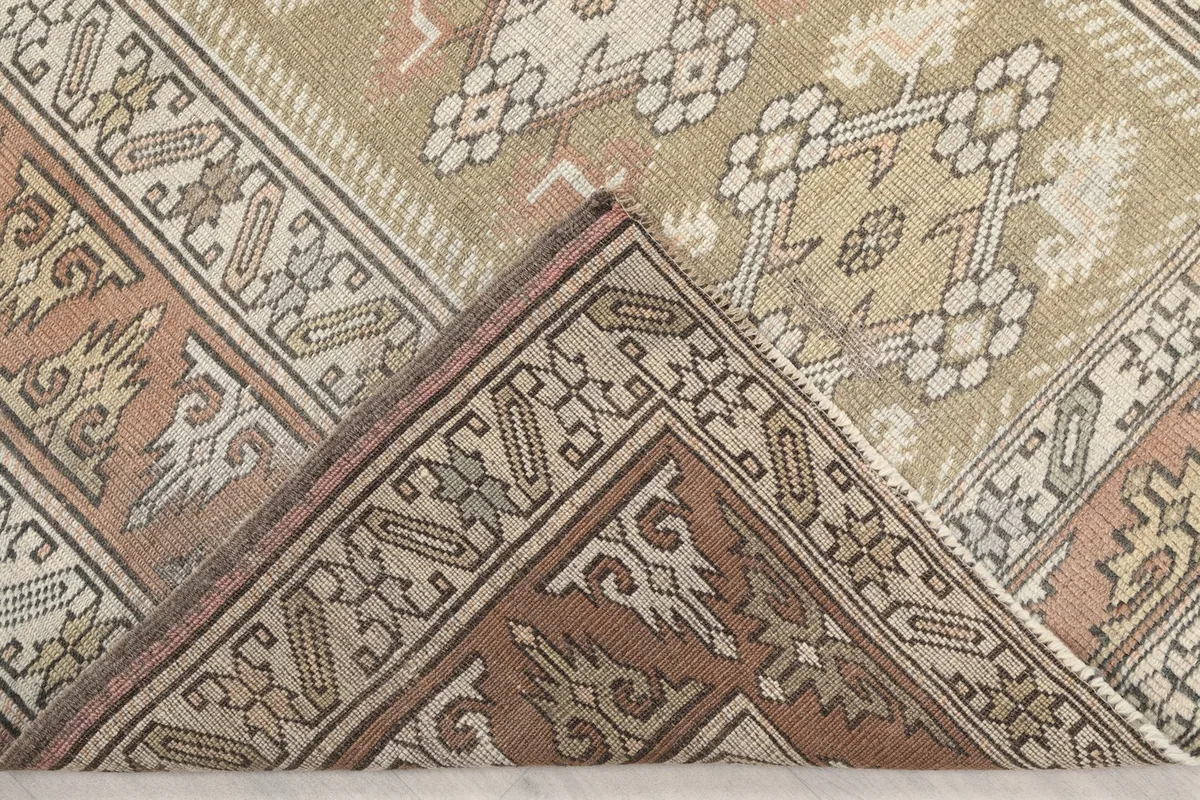 Corner of the rug folded to reveal the hand-knotted cotton foundation