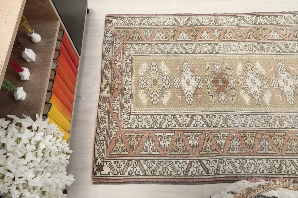High-angle view of the rug's pattern, showcasing the beige field and rust border