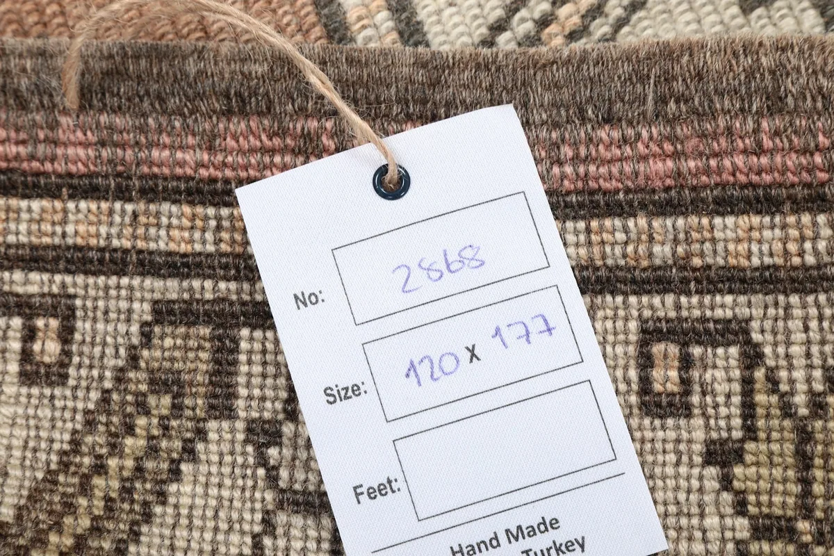 Product tag displaying the rug's dimensions and handmade origin