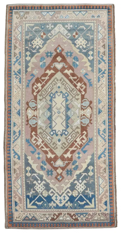 Full top view of the vintage Anatolian rug with rose, blue, and rust geometric patterns.