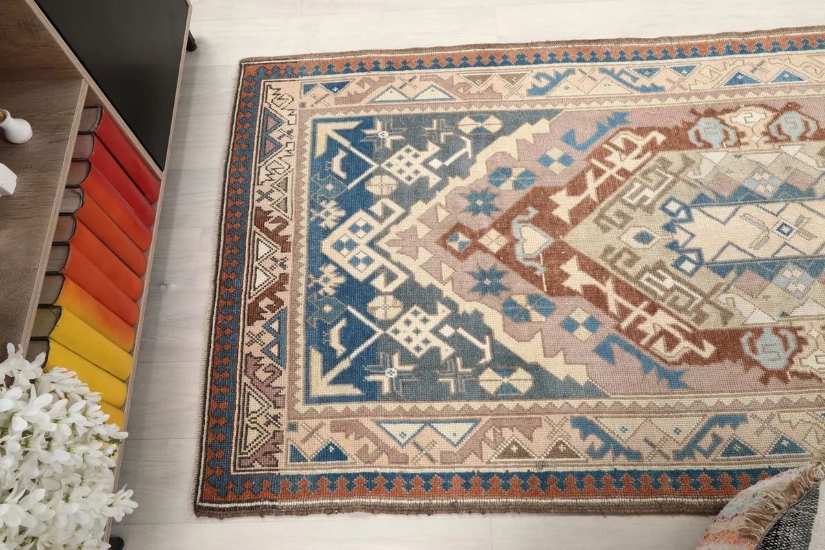 Angled view of the rug's upper section, displaying the full breadth of its tribal design.