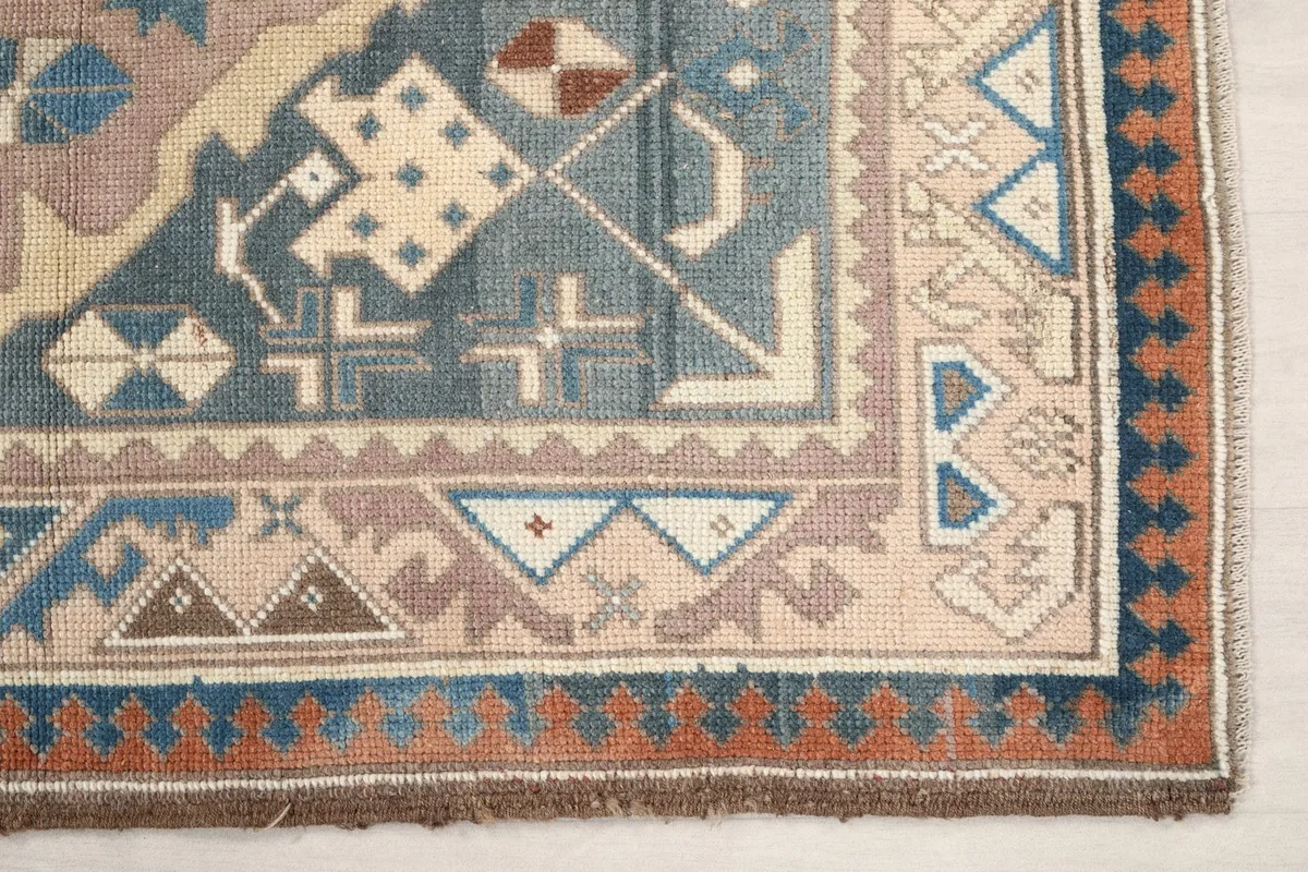 Close-up of the lower left corner border and field, highlighting rust and blue details.