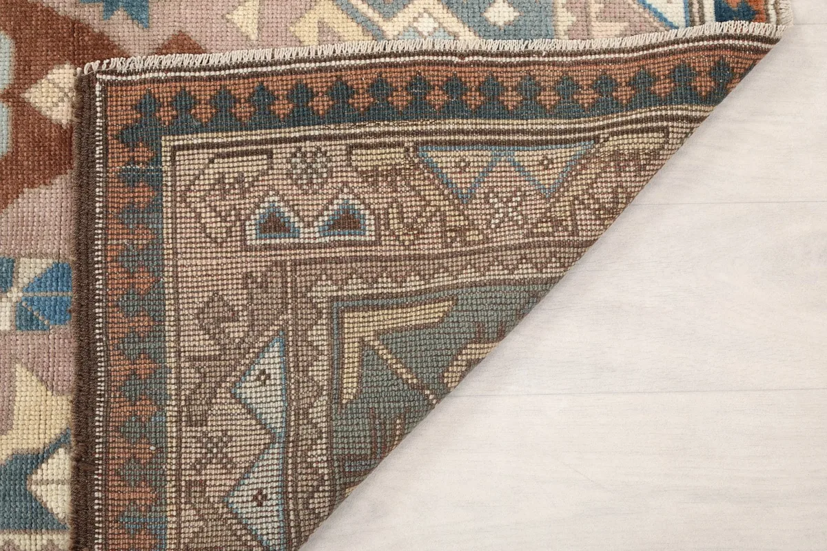 Another view of the folded corner, showing the rug's reverse side and weave structure.