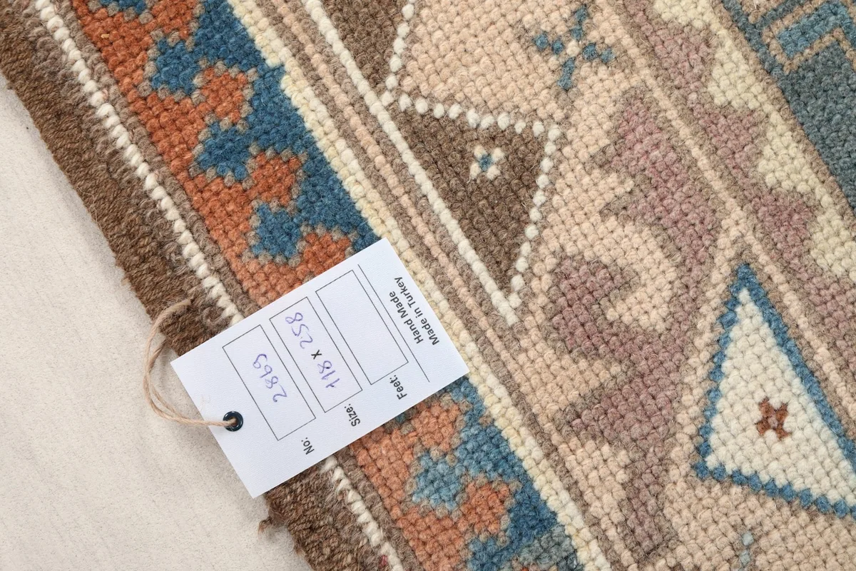 Close-up of the rug's edge with a tag showing its dimensions and origin.