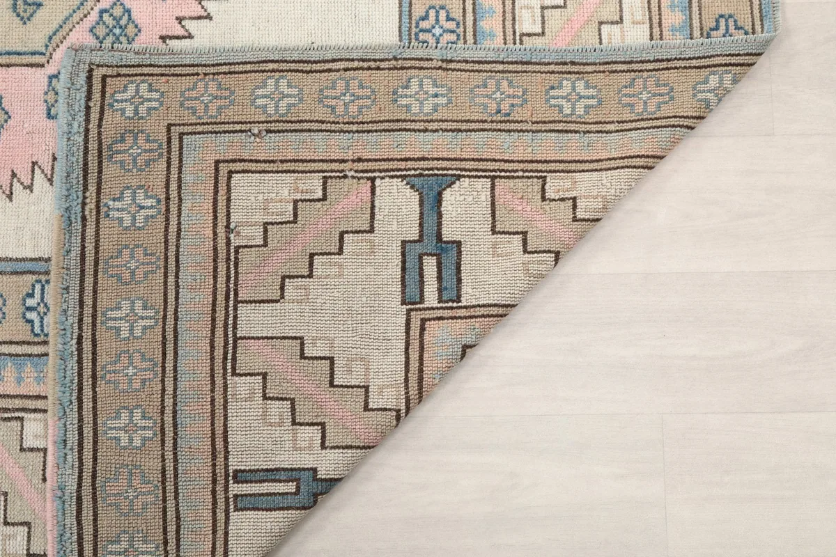 Underside of the rug, showing the hand-knotted cotton foundation and back of the pile