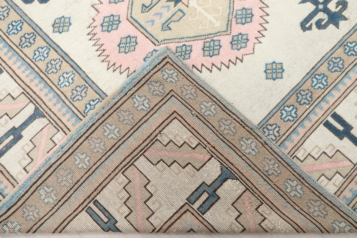 Folded corner of the rug revealing the cotton foundation beneath the wool pile