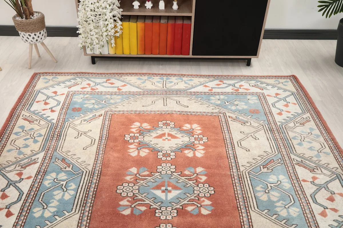Overhead view of the vintage rust and blue rug in a room, showing its full design