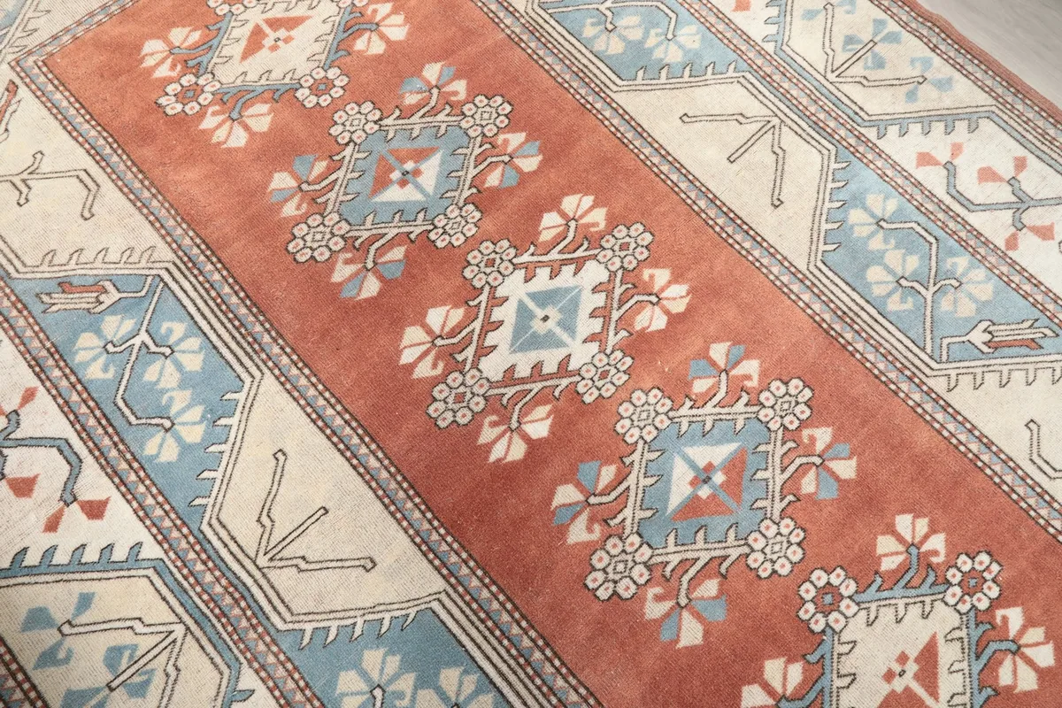 Close-up of the central rust field with geometric motifs in blue and cream