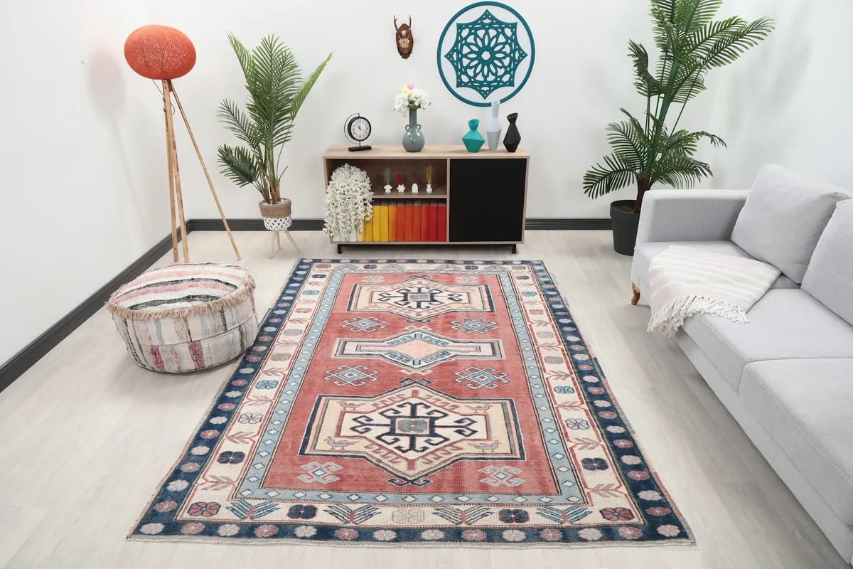 Vintage rug with rust and navy colors in a living room setting with a sofa