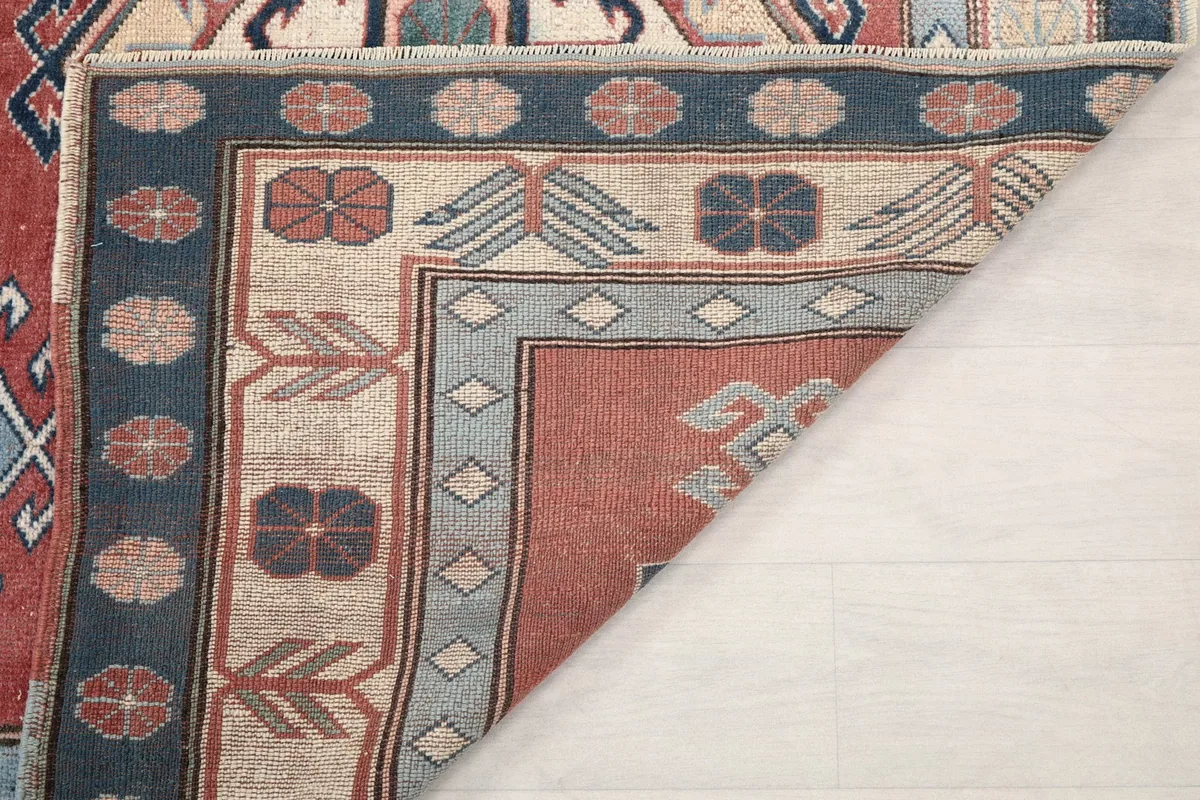 View of the back of the rug, showing the hand-knotted wool on cotton foundation