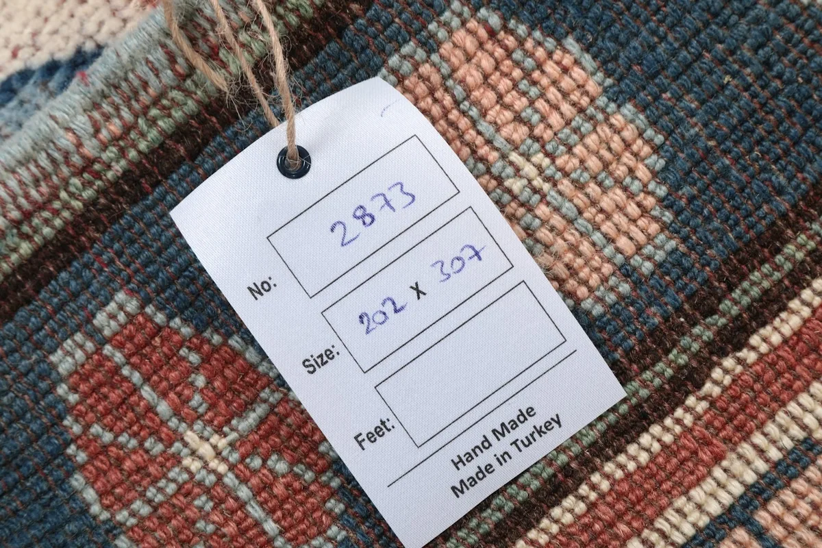 Tag showing the rug's dimensions and origin, 'Hand Made Made in Turkey'