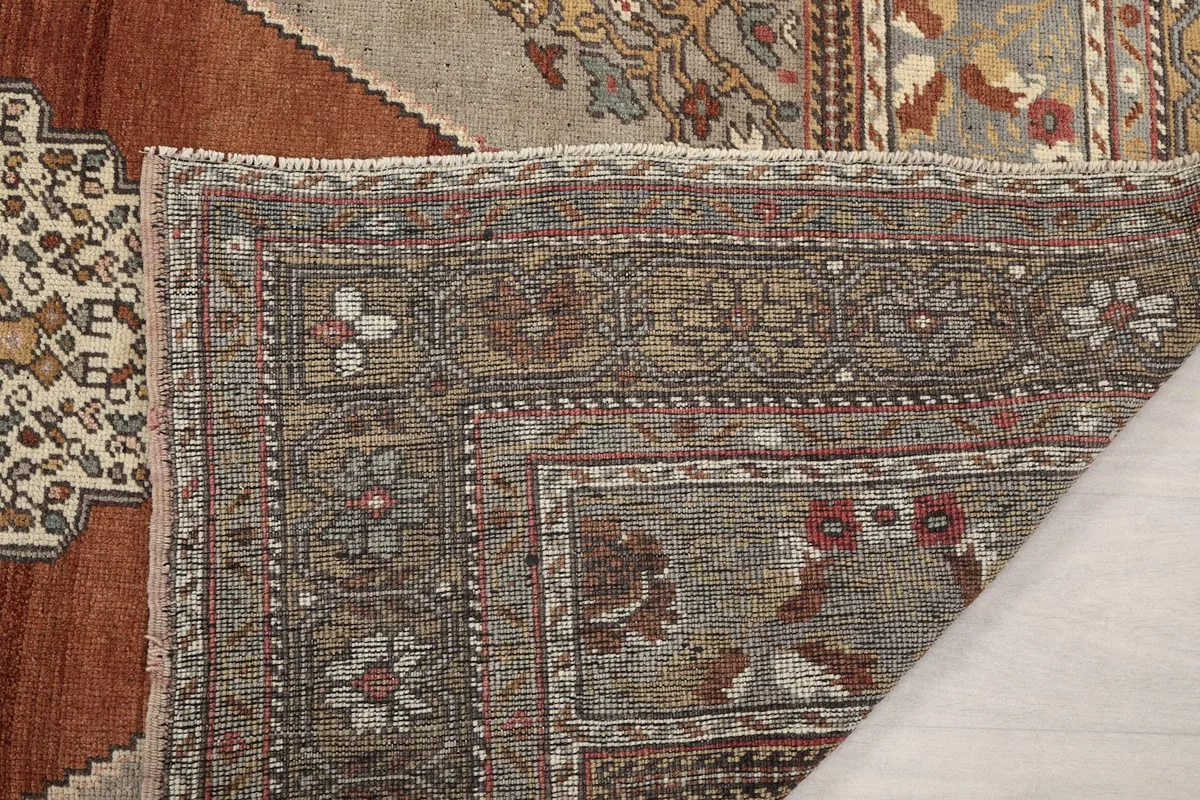 Close-up of the back of the rug, revealing the tightly woven cotton foundation and hand-knotted details