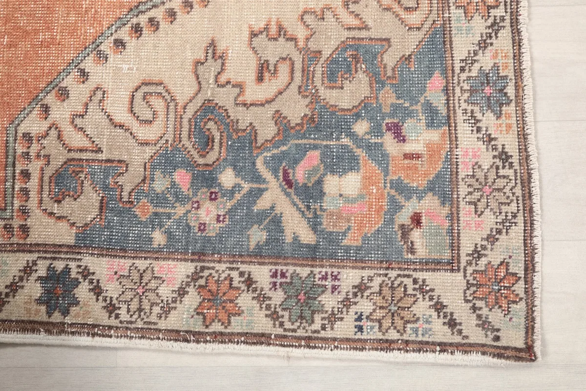 Detailed view of the corner motif and border, showing blue, beige, and pink elements