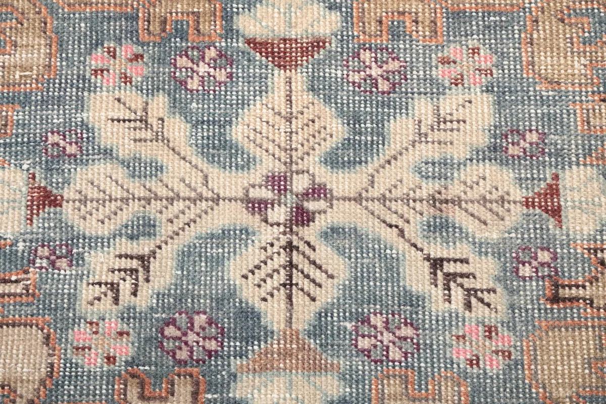 Texture close-up showing the hand-knotted wool pile and intricate details of the blue pattern