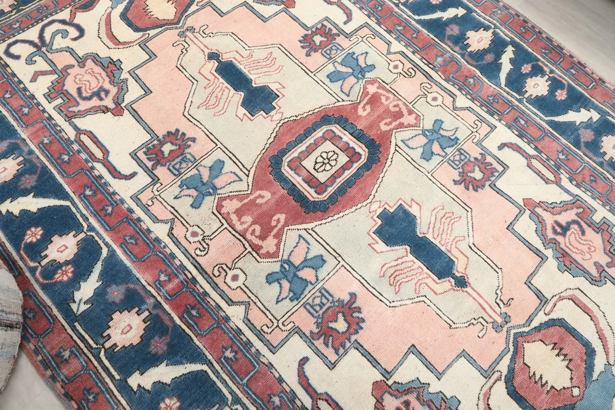 Close-up of the intricate pink and navy motifs within the rug's field
