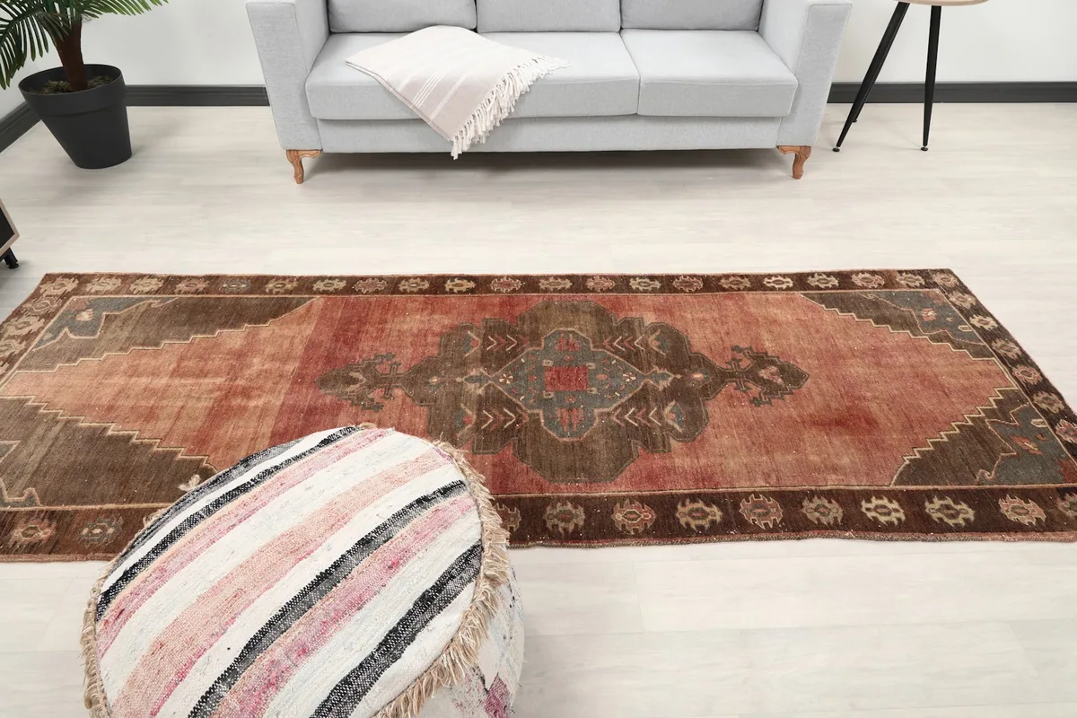 Overhead view of the entire runner rug in a room, with a sofa and pouf.