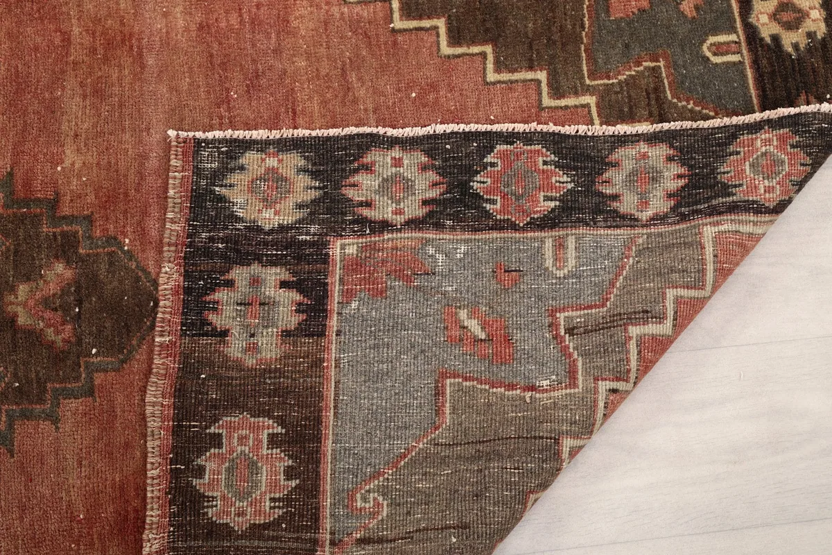 Close-up showing the low pile, wool knots, and intricate weaving on the back of the rug.