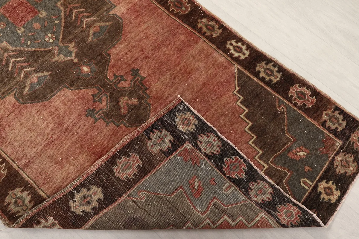 Corner of the rug folded to show the hand-knotted cotton foundation and wool pile.