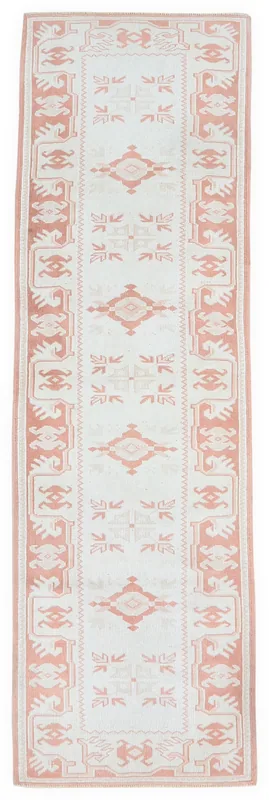 Full overhead view of a 2x9 cream and rust geometric Anatolian runner rug