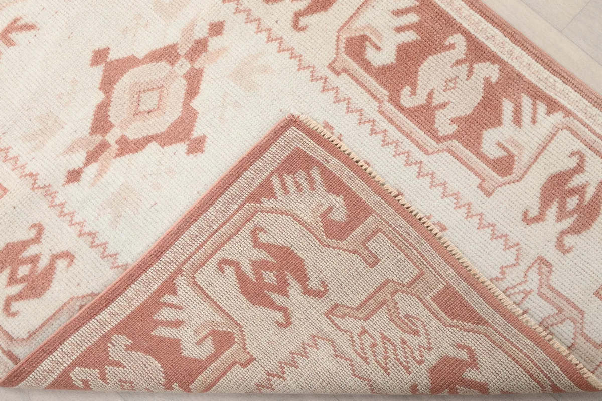 Folded corner of the rug, revealing the wool pile and cotton foundation
