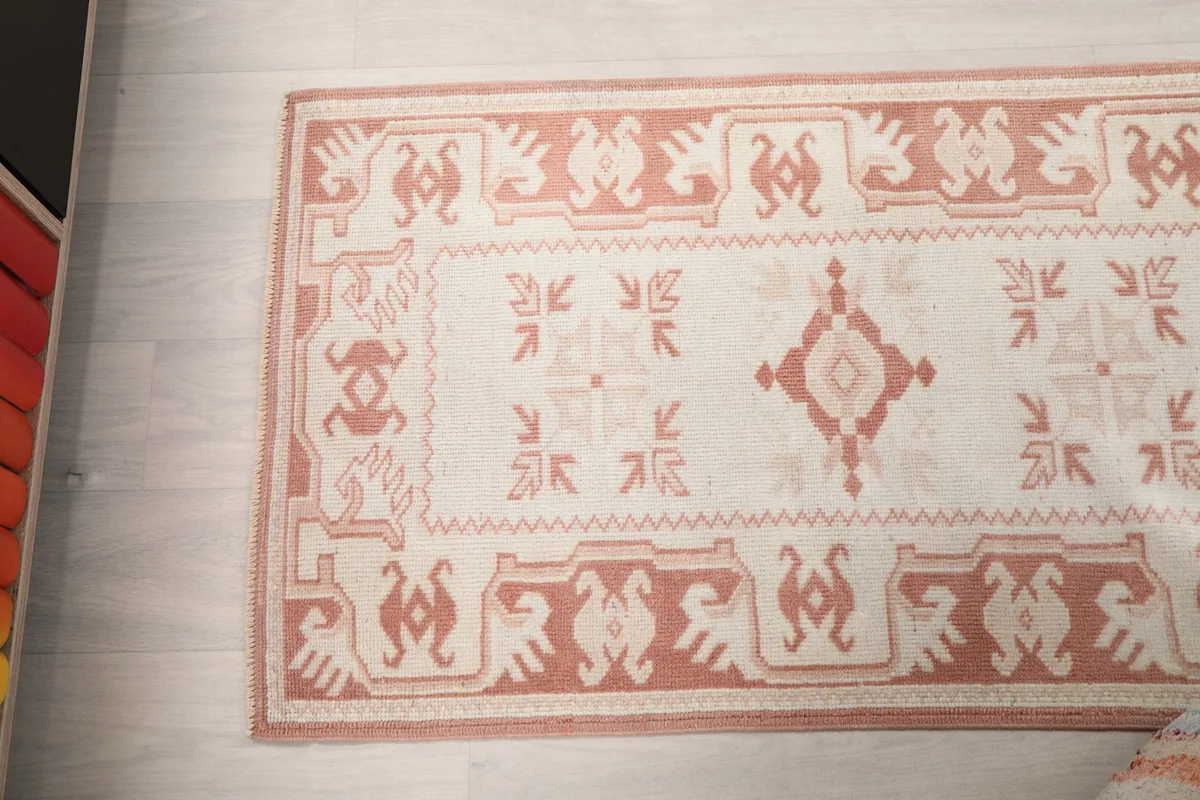Overhead close-up of the rug's patterns and colors, focusing on the field and border