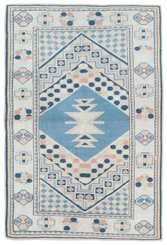 Full overhead view of the cream and blue tribal geometric vintage Anatolian rug