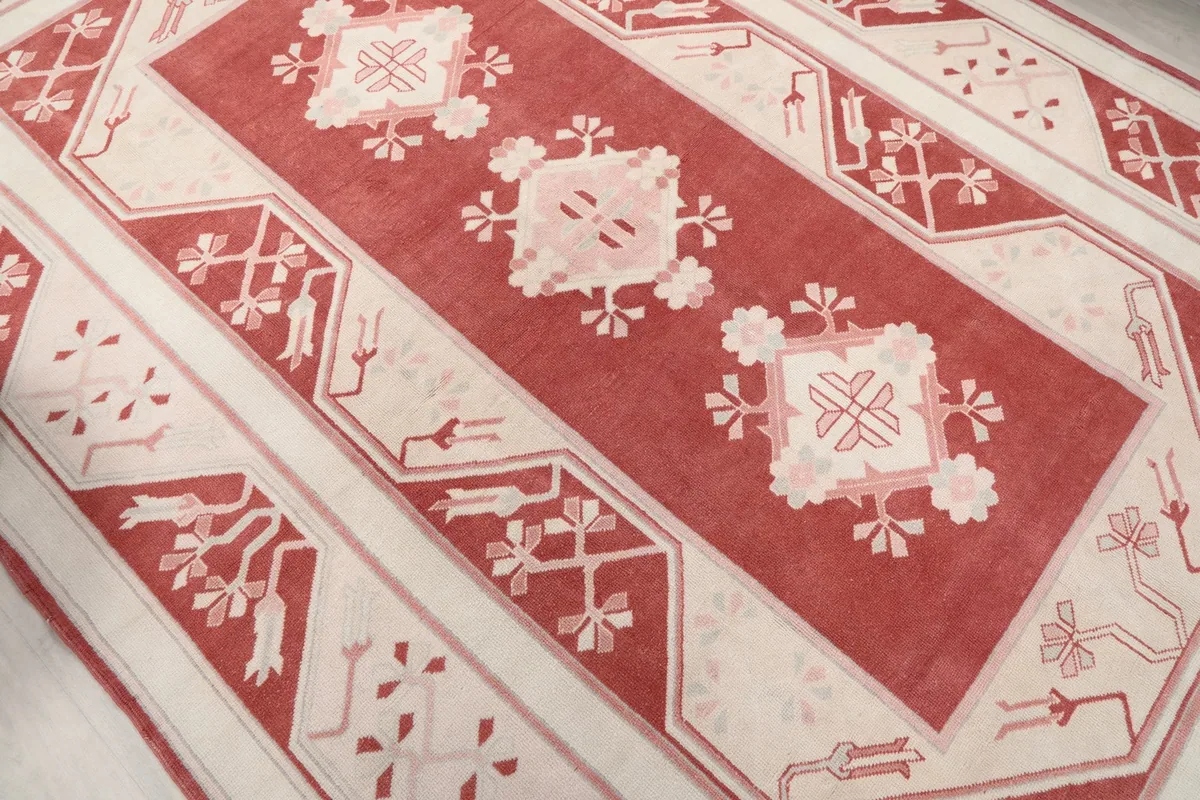 Angled shot showcasing the main field and border patterns of the hand-knotted rug.