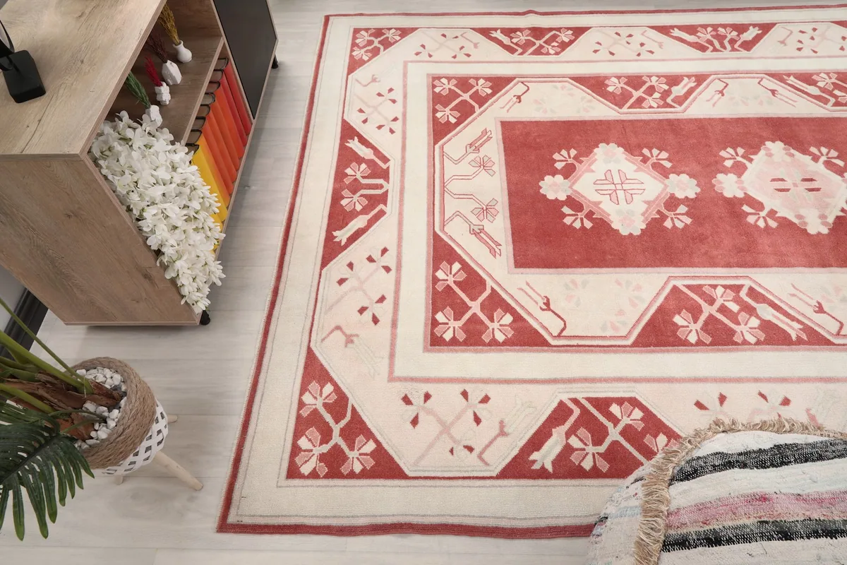 View of the rug in a room, focusing on the border and field design near furniture.
