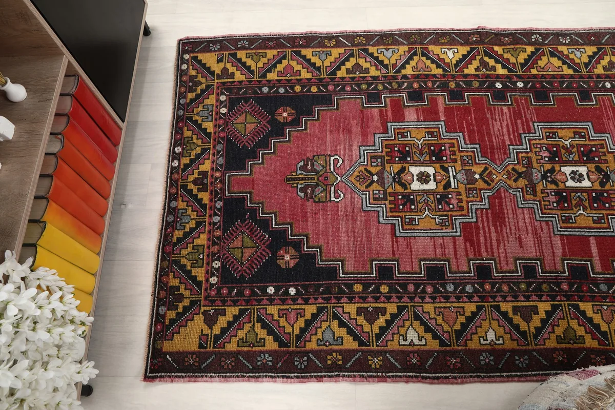 Angled overhead shot focusing on the upper half of the rug, showing the central medallion and surrounding patterns.