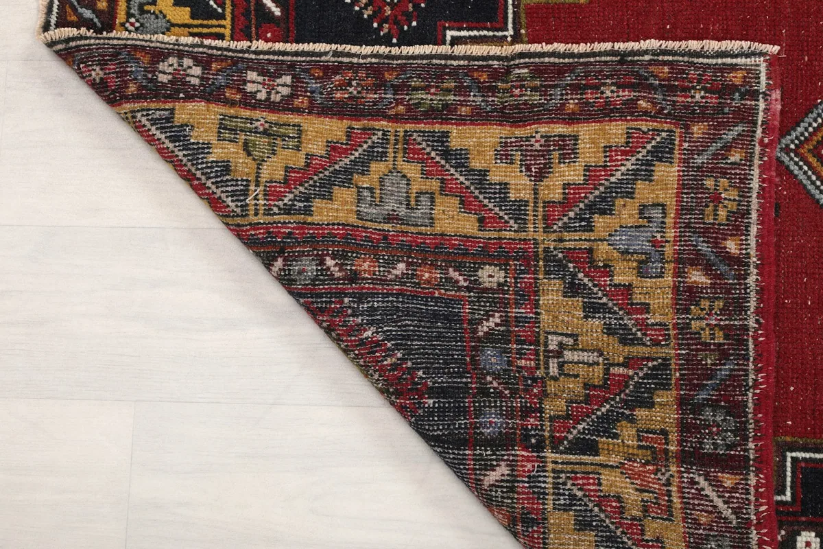 Close-up of a folded corner, showing the rug's construction from the back and the texture of the pile.