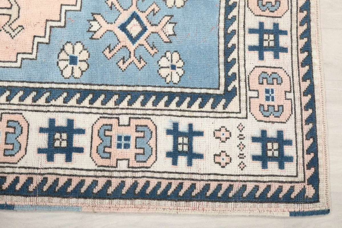 Detail of the rug's border with navy and ivory geometric motifs