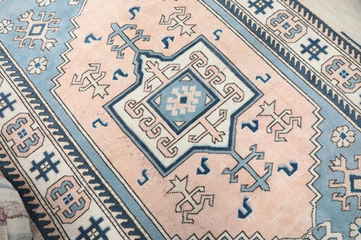 Close-up of the central medallion and tribal elements on the pink field