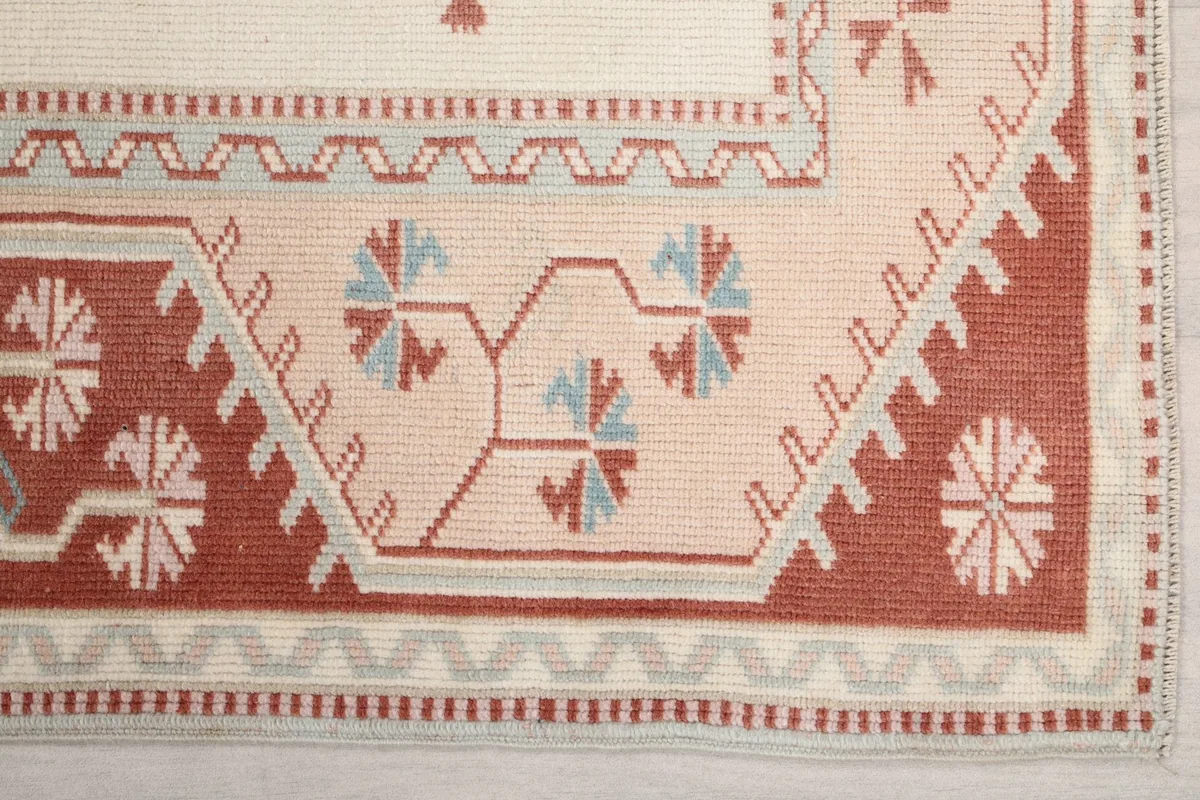 Detailed view of the rust and beige border with tribal patterns and light blue accents