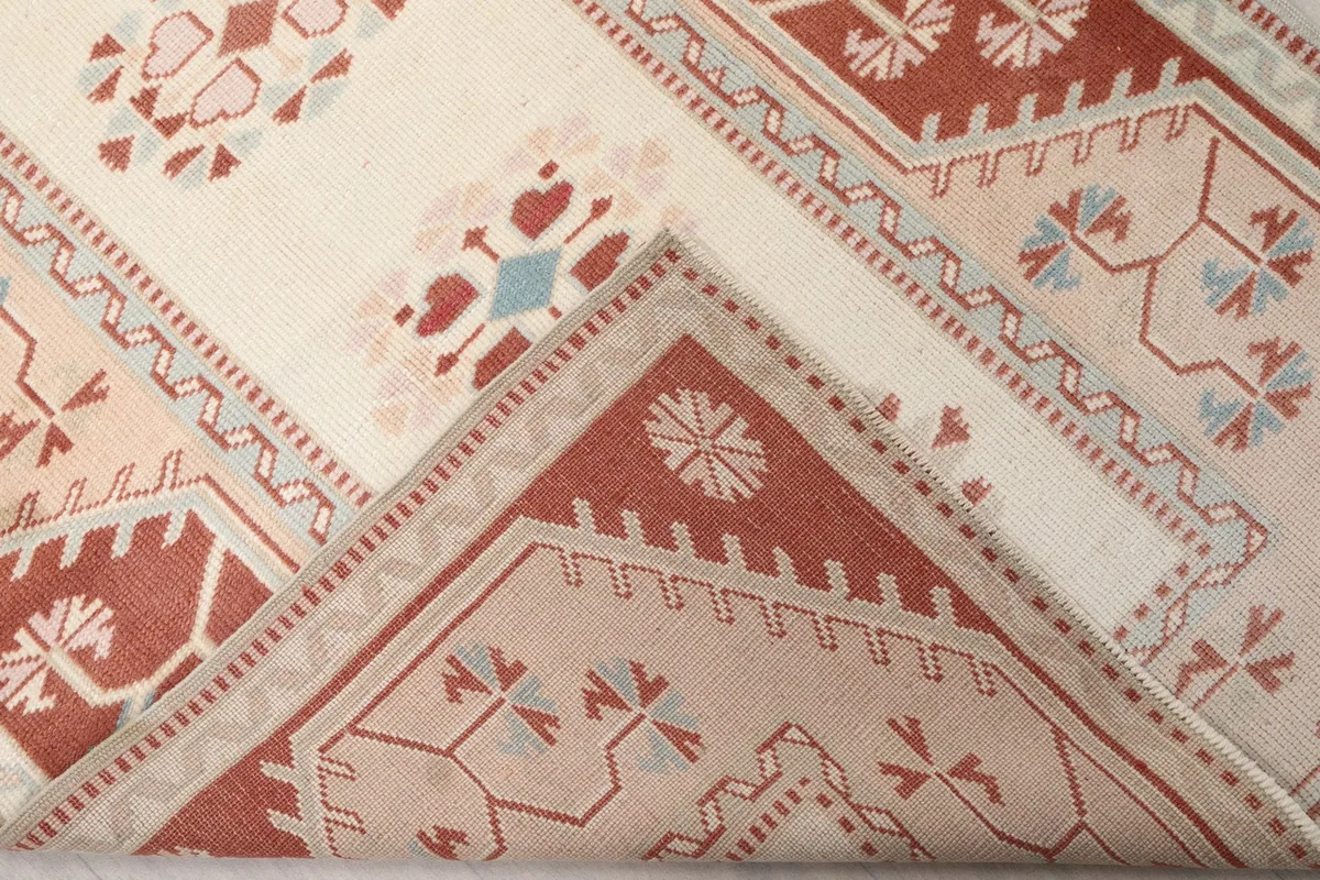 Folded corner of the rug, revealing the wool pile texture and the cotton foundation