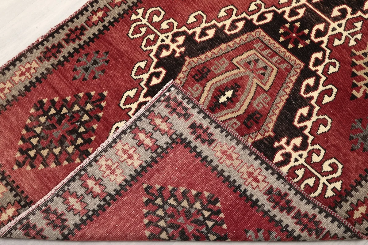 Corner of the rug folded back to show the cotton foundation and reverse side