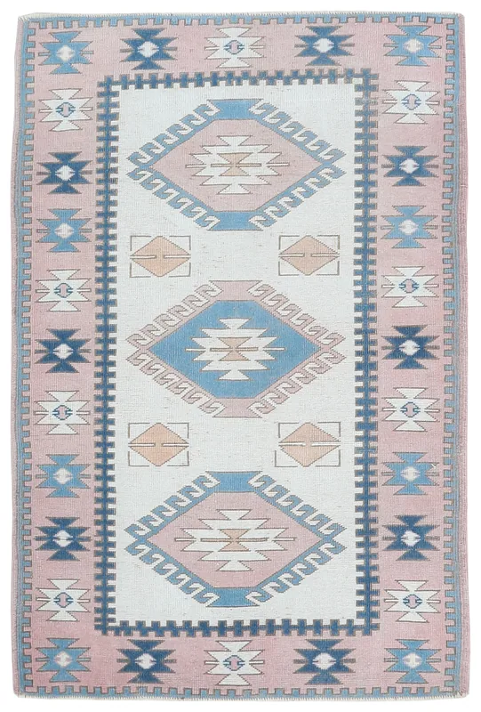 Top view of a 4'1" x 6'2" rose, ivory, blue, and tan tribal geometric area rug