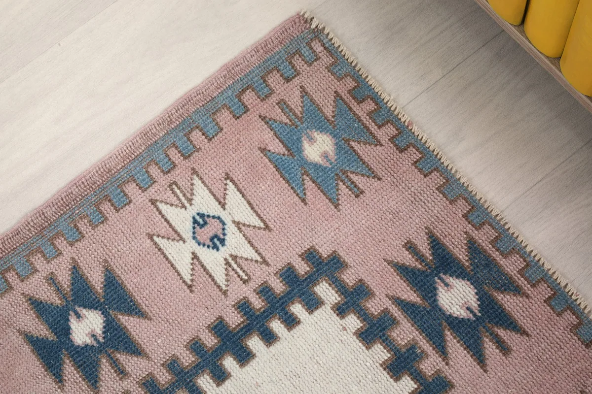 Corner detail of the rose border with blue and ivory geometric patterns