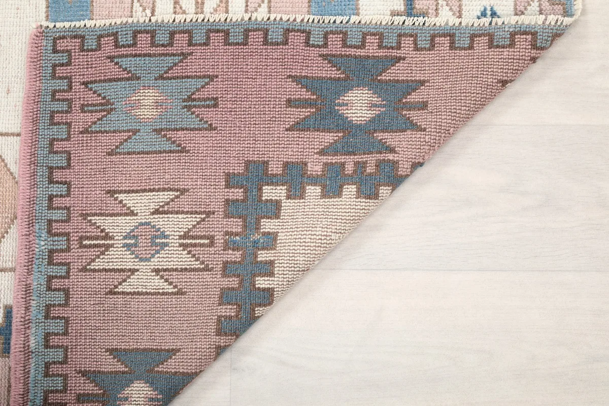 Another folded corner view showing the back of the hand-knotted vintage rug