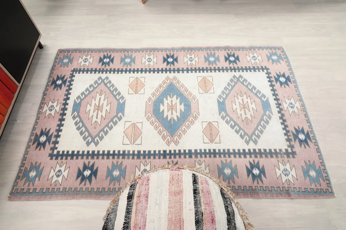 Overhead shot of the small area rug with a pouf partially in the frame