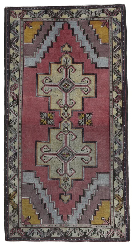 Full top view of the 4'11" x 8'4" rose and ivory geometric Anatolian rug